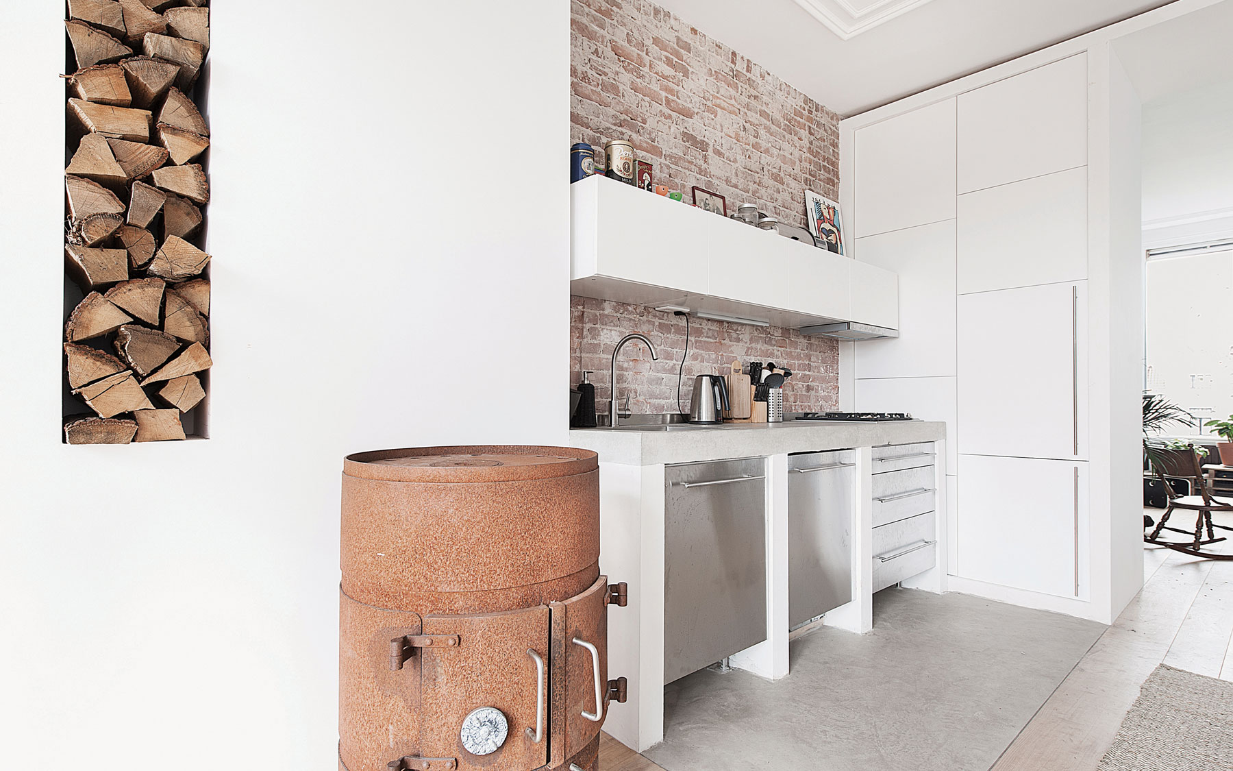 Moderný, funkcionalistický vzhľad apartmánu podčiarkujú použité industriálne prvky ako kuchynská linka z antikora s matným povrchom, skorodované kachle...