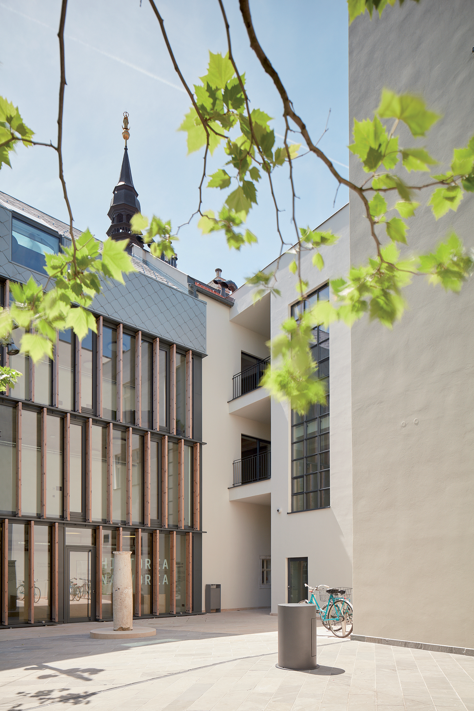 Pohľad na prechod medzi novou a pôvodnou časťou budovy spolu s vystaveným pranierom.