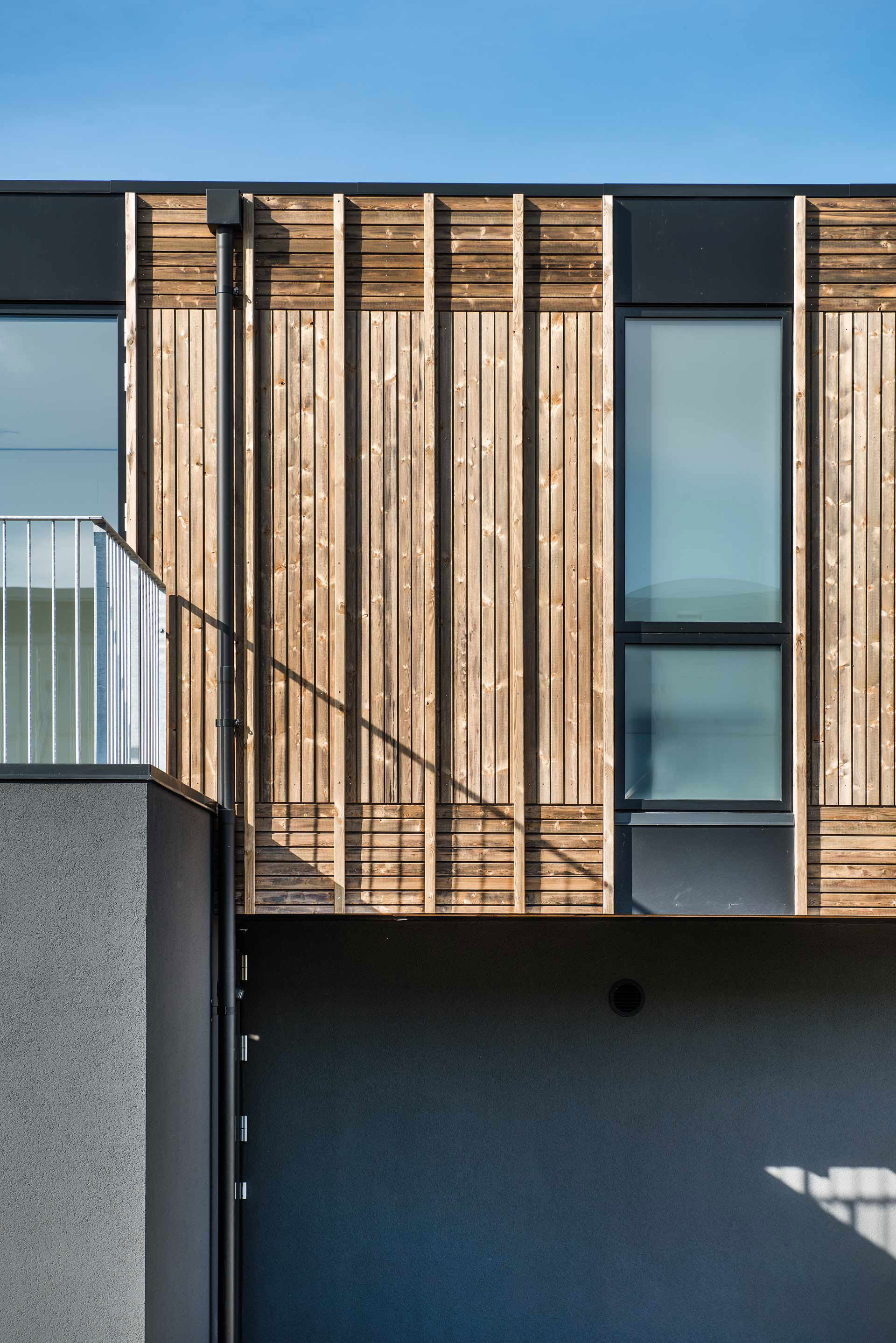 Súčasťou fasády sú aj drevené clony, ktoré bránia prehrievaniu interiéru.