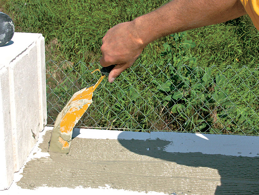 04 | Obvodové murivo Následne možno pokračovať v murovaní obvodového múru – murovacia malta sa nanáša na celú šírku muriva, a to tak, aby úplne zakryla upevnenú spojku. Spojky muriva sa osadia v každom druhom rade tvárnic nosnej steny.