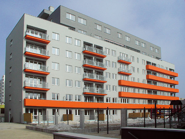 Dom s oranžovým detailom a so zeleným dvorom